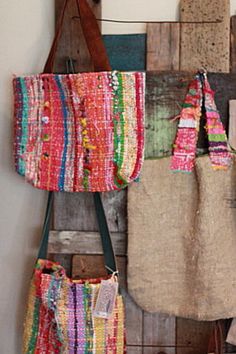 several bags hanging up against a wall with wooden boards attached to the wall behind them