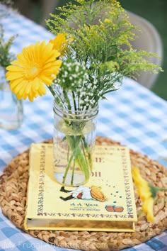 a vase filled with flowers sitting on top of a table next to a blue and white checkered table cloth