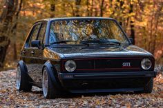 an old car is parked in the leaves