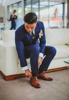 a man in a suit tying his shoes