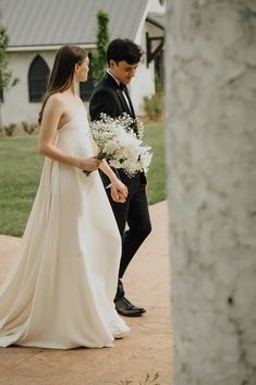 the bride and groom are walking down the sidewalk