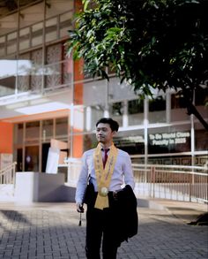 a man walking down the street wearing a yellow and black tie