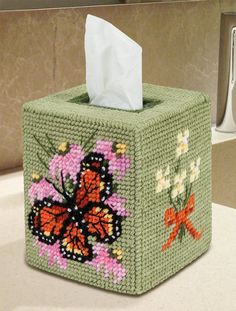 a green tissue box with a butterfly design on it