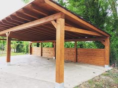 an outdoor covered area with wooden posts and wood slats on the side of it