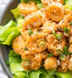 a close up of a bowl of food with lettuce and sauce on it