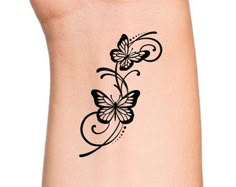 a black and white butterfly tattoo on the side of a woman's arm,