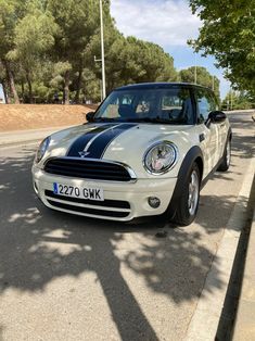 a white and black car is parked on the side of the road