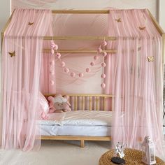 a pink canopy bed in a girls bedroom