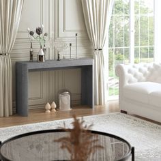 a living room with white furniture and curtains