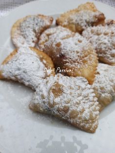 powdered sugar covered pastries on a white plate