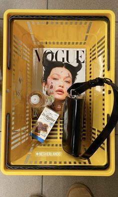 a yellow basket with magazines and other items on it