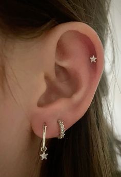 a close up of a person's ear with two small stars on the side