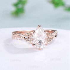 a rose gold ring with a white diamond in the center and an intricate band around it