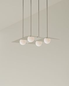 four lights hanging from the ceiling in an empty room