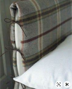 a bed with a plaid headboard and white pillows