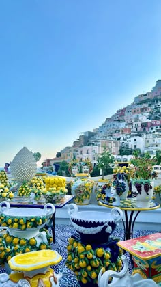 there are many vases and bowls on the table with lemons in each one