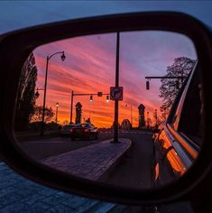 a car's side view mirror reflecting the sunset