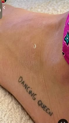 a woman's foot with the words dancing queen tattooed on her left leg and an arrow in the middle