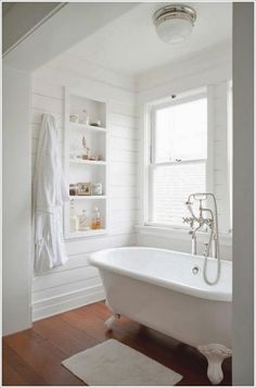 an instagram page with a white bathtub and wooden floors