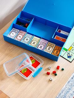 a blue box filled with lots of dice and numbers on top of a wooden table