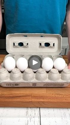 a man holding an egg carton filled with white eggs