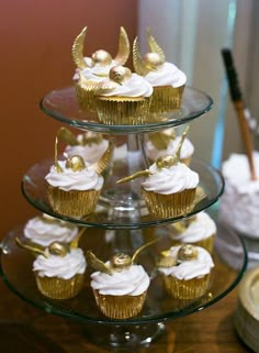 cupcakes are stacked on top of each other with angel wings and gold decorations