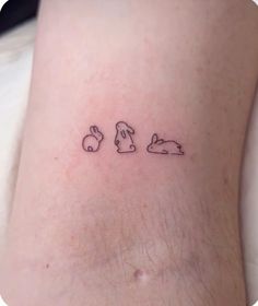 a small tattoo on the leg of a person with bunny ears and bunnies behind them