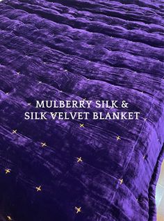 there is a purple bed with gold stars on it and the words mulberry silk & silk velvet blanket