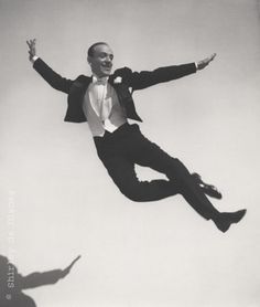 a man in a tuxedo jumps into the air