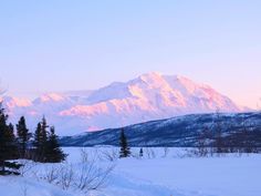 the mountains are covered in snow and trees