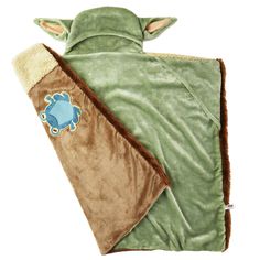 a green and brown blanket with a blue turtle on it's back, sitting next to a white background