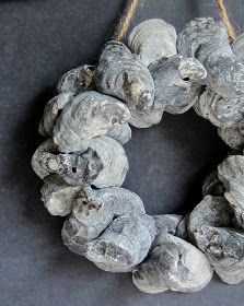 a wreath made out of driftwood is hanging on a black tablecloth with rope