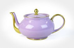 a purple tea pot with a gold handle