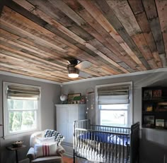 a baby's room with wood planks on the ceiling