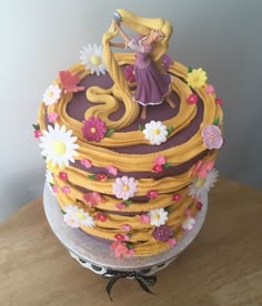 there is a cake that has been decorated with flowers and a princess figure on top