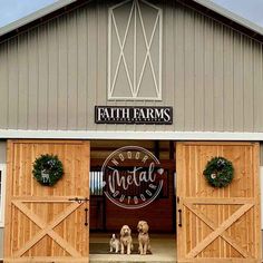 two dogs are sitting in front of the entrance to a farm store with wreaths on it