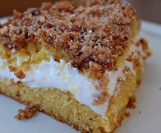 a close up of a piece of cake on a plate with whipped cream and pecans