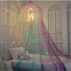 a canopy bed with fairy lights on it