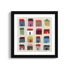 a framed art print with houses in different colors and sizes on the front, against a white background