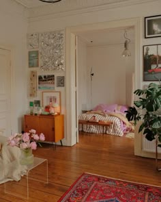 a living room filled with lots of furniture and flowers on top of a wooden floor