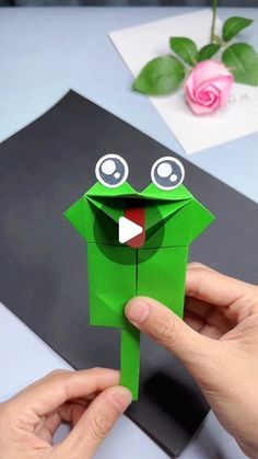 someone is making a frog out of paper