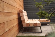 a wooden bench sitting next to a wall