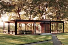 the glass house is surrounded by trees and grass