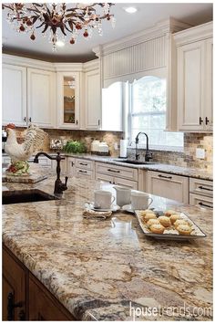 a kitchen with marble counter tops and white cabinets