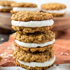 a stack of cookies with marshmallows and frosting on top, sitting next to each other