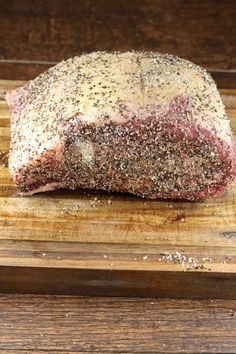 a piece of meat sitting on top of a wooden cutting board