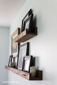 the diy picture shelf is made from wood and has three frames on it, along with