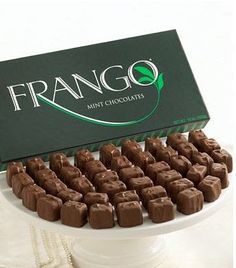 a box of frango chocolates sitting on top of a white cake with a green sign above it