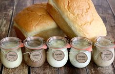 bread and jams are sitting on the table next to each other in small jars