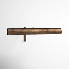 an old brass pipe is hanging on the wall in front of a white background with space for text